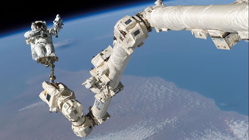 Cánh tay robot Canadarm2 của Trạm không gian quốc tế (ISS) giúp đưa phi hành gia Steve Robinson vào vị trí thích hợp trong hoạt động ngày 3/8/2005.